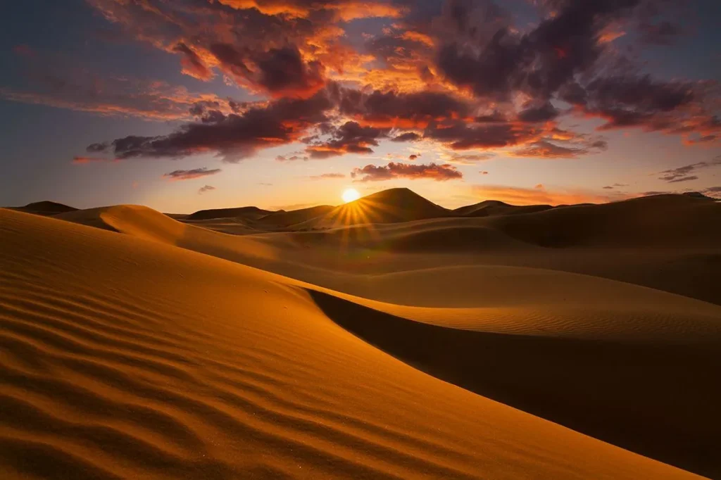 Sunset casting warm hues over the desert landscape, transitioning from Casablanca's vibrant cityscape to serene dunes.
casablanca to desert