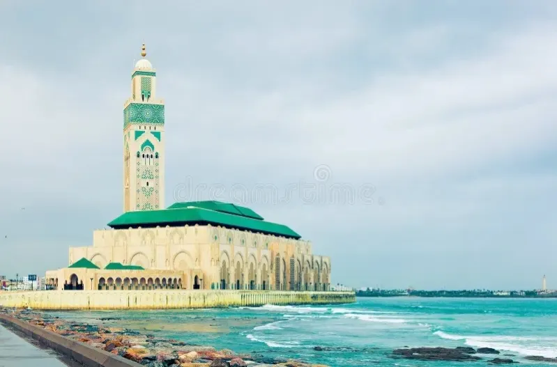 A panoramic view of the Hassan II Mosque in Casablanca Morocco, showcasing its intricate architecture and coastal setting.