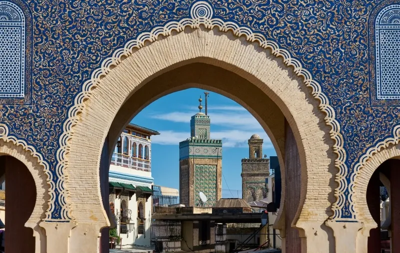 A blue and white archway with a blue tile roof, showcasing traditional Moroccan architecture.