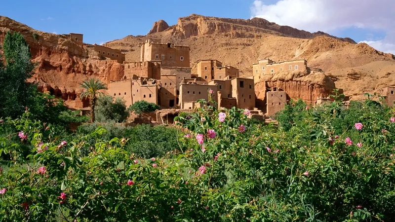 A panoramic view of the village of Atlas nestled in the desert, showcasing its unique architecture and surrounding landscape.with the best time to travel to Morocco