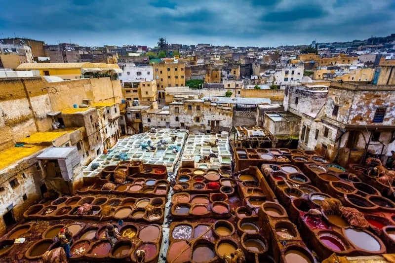Colorful pots and pans displayed in a bustling Marrakech market, showcasing the vibrant culture and craftsmanship of Morocco.