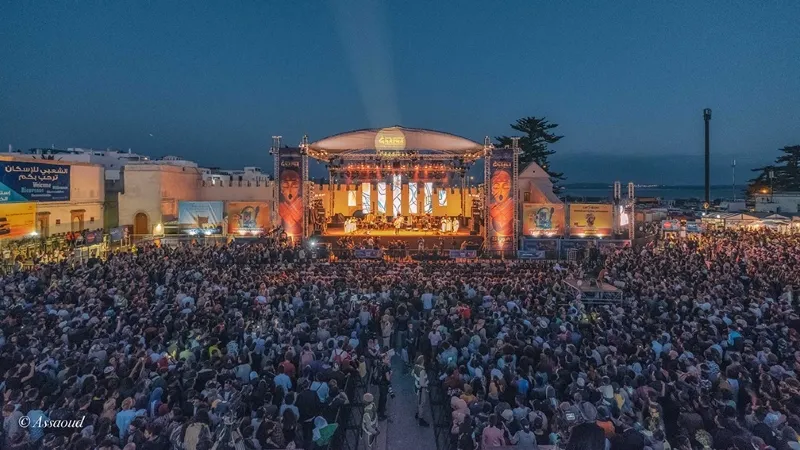 A large crowd enjoying live music at a vibrant festival in Marrakech, Morocco, showcasing the city's lively culture.