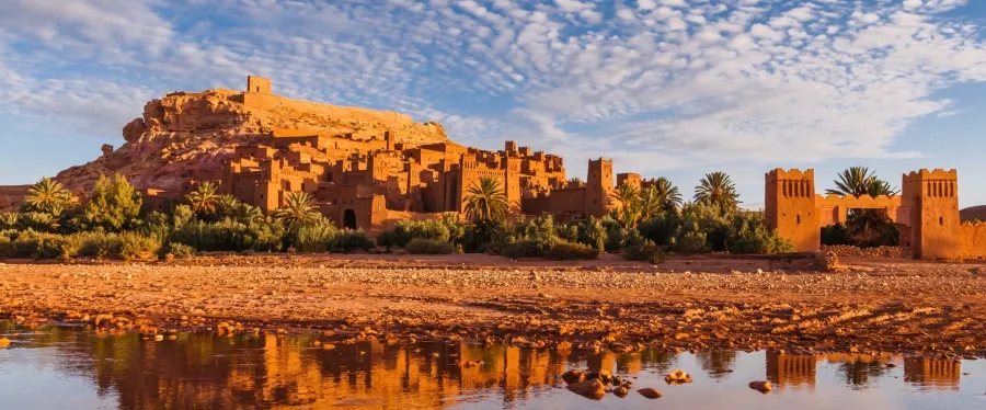 Ruins of a medieval castle in Morocco, showcasing ancient stone walls and towers against a clear blue sky.