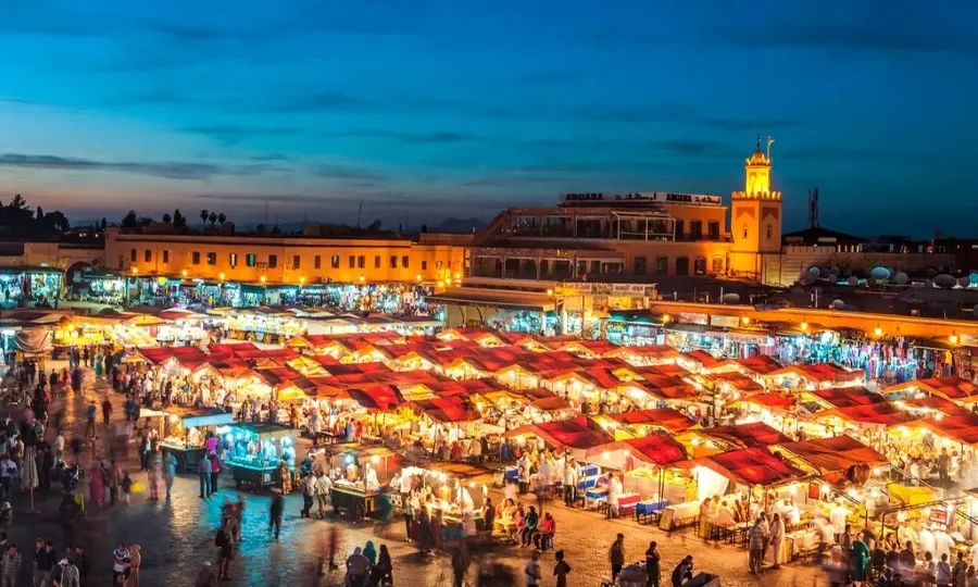 Night view of Marrakech, Morocco, showcasing vibrant lights and bustling streets, highlighting the city's lively atmosphere.