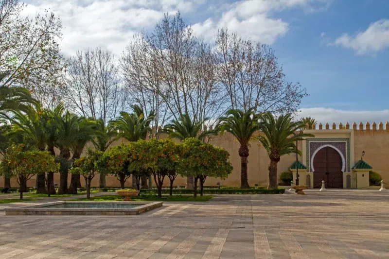 Courtyard of the Sultan's palace in Fes Morocco attractions , showcasing intricate architecture and lush greenery.
