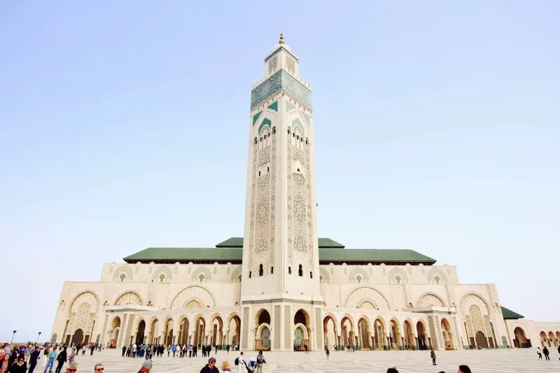 The grand mosque of Casablanca, an iconic symbol of Morocco, showcases intricate design and grandeur in a desert setting.