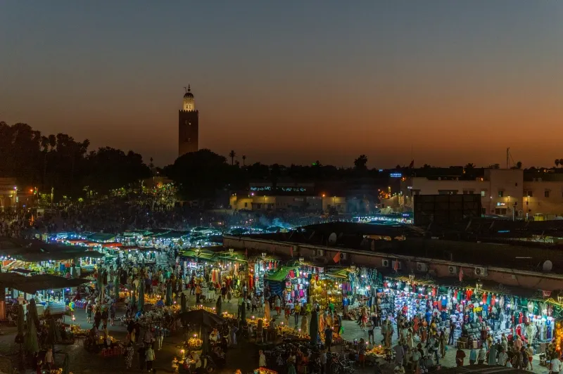 Marrakech skyline at dusk, showcasing vibrant colors and iconic architecture, highlighting key attractions in the city.