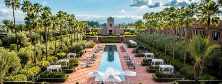 Tranquil pool surrounded by lush greenery at a Marrakech riad, a must-see attraction in the city.