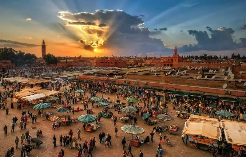 The moon illuminates tents in the desert during a trip to Marrakech, creating a serene nighttime atmosphere.