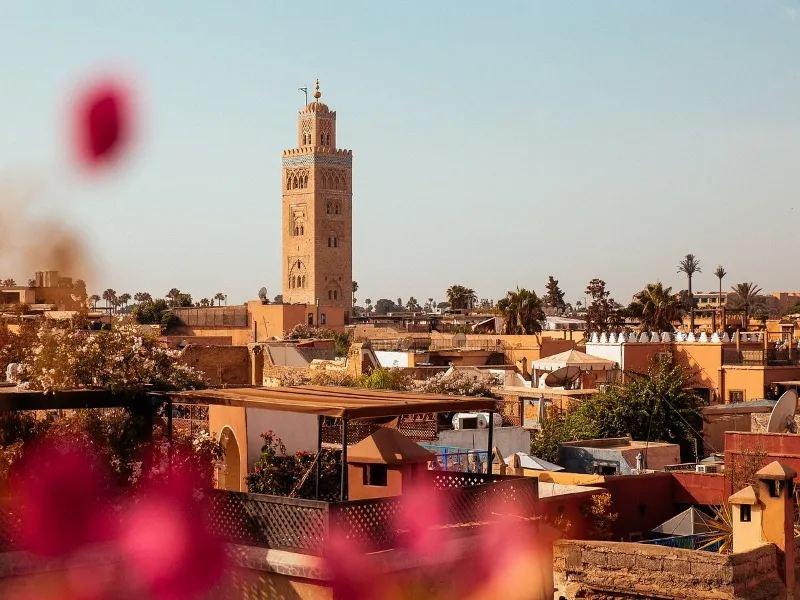 Marrakech's skyline with a clock tower in the background, capturing the essence of the city on a memorable trip.