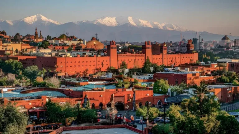 Marrakech cityscape with snow-capped mountains in the background, showcasing Morocco's stunning natural beauty.